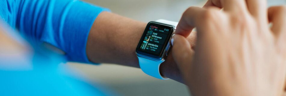 person in blue long sleeve shirt using smart watch