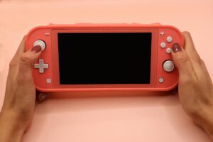 woman holding a pink nintendo switch lite console